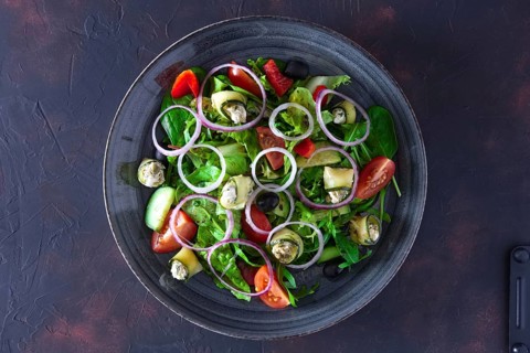 Fresh salad with zucchini stuffed with feta cheese with tomato