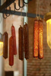 Smoked sausagees hanging on a hook under the ceiling. Photo with shallow depth of field