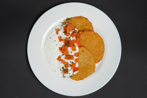 Top view of traditional belorussian potato pancakes with salmon and sour cream