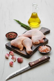 Raw chicken thighs on wooden cutting board ready for cooking
