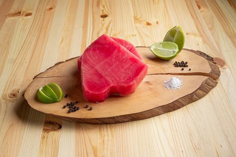 Fresh raw tuna steak on wooden cutting board