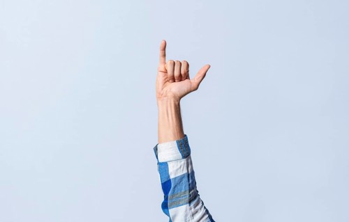 Hand gesturing the letter Y in sign language on an isolated background. Man's hand gesturing the letter Y of the alphabet isolated. Letter Y of the alphabet in sign language