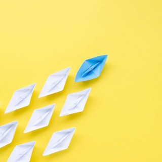 Composition individuality concept with paper boats yellow background