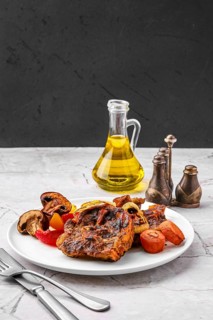 Lamb neck with champignon and vegetables baked in oven on a plate