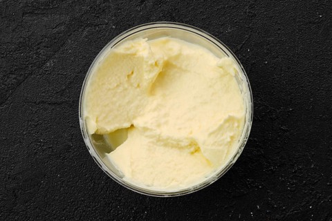 Homemade mascarpone in plastic bowl