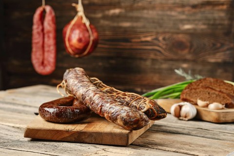 Air dried beef meat and pork sausage on wooden cutting board