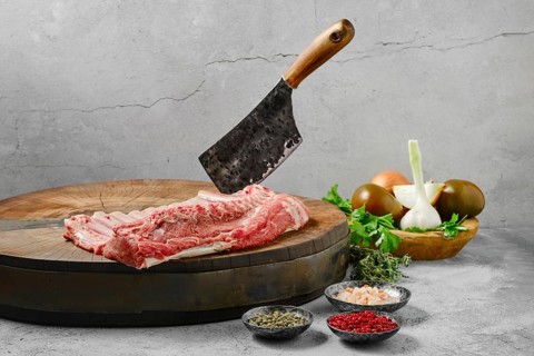 Raw whole rack of lamb on wooden slab