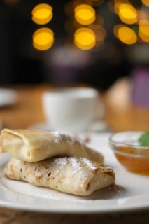 Soft focus photo of pancakes with jam and cup of coffee. Breakfast at a cafe