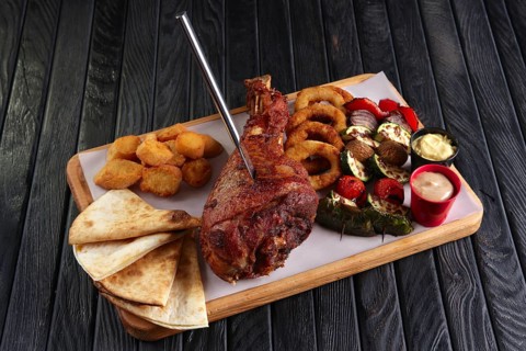 Fried turkey thigh with grilled vegetables and snack for beer