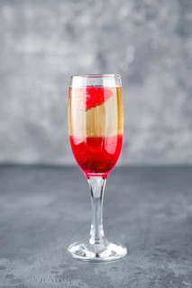 Strawberry cocktail with sparcling wine on gray shabby background