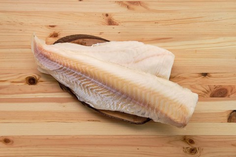 Frozen fillet of cod on wooden table