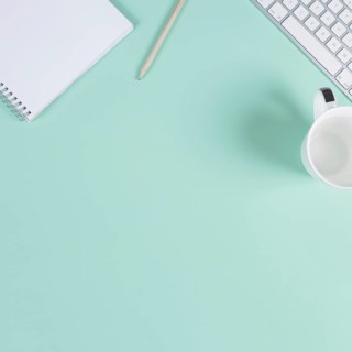 Close up blank notepad pencil cup keyboard turquoise background with space text