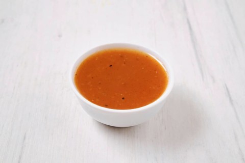 Small bowl with spicy orange sauce for poultry