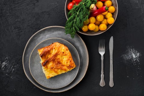 Georgian pie with cheese achma on black wooden background