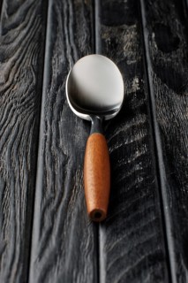 Soft focus photo of stylish spoon with wooden handle