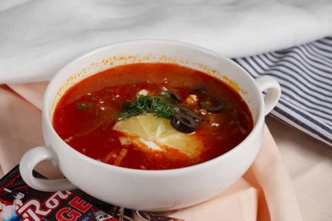 Russian traditional solyanka soup. Authentic soup saltwort in ceramic plate