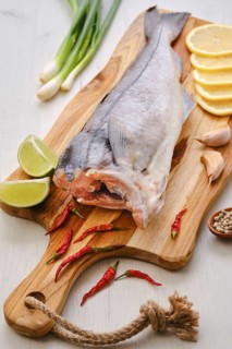 Raw fresh haddock carcass on wooden cutting board