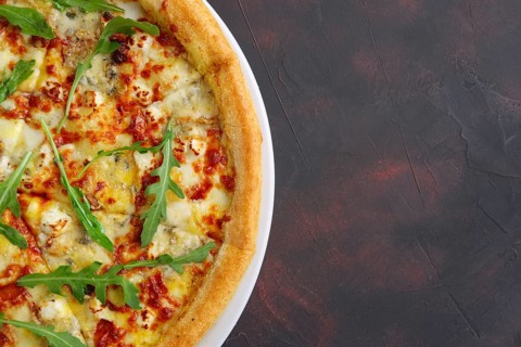 Top view of four cheeses delicious pizza with thick crust