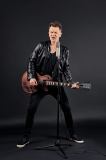 Full length portrait of artist playing guitar