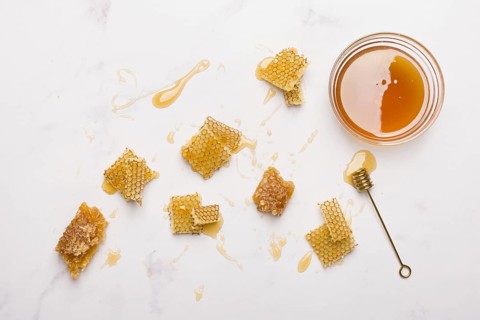 Glass jar full honey with honey spoon