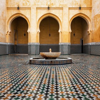 Fountain in front of arcades in the courtyard