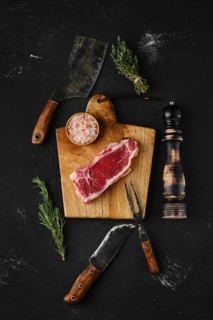 Overhead view of raw strip steak boneless on dark background