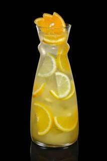 Decanter with orange and lemon lemonade isolated on black