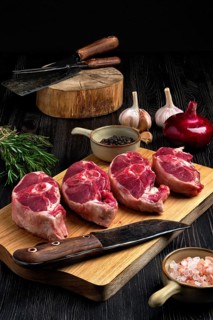 Chopped fresh lamb shank steak with spice on cutting board with spice