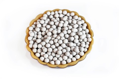 Top view of unbaked tart filled with ceramic pie weights used to keep crust from shrinking during blind baking