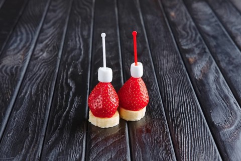 Appetizer for reception. Fresh banana with strawberry and small marshmallows on skewer