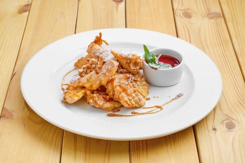 Deep fried fruits in breading served with caramel and strawberry jam