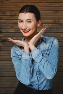 Pretty fashion model in jeans shirt with tan makeup and red mat lips on wooden background