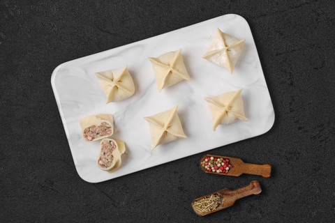 Top view of homemade spicy beef dumplings on marble serving plate