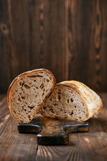 Loaf of artisan sourdough bread with porous texture cut on half