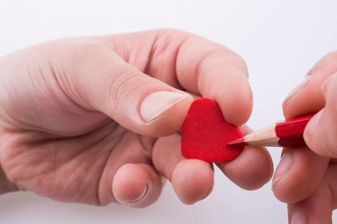 Pencil pointing a red heart