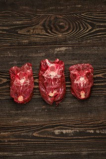 Overhead view of raw fresh deer neck over dark wooden background