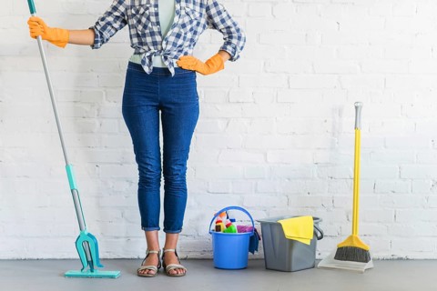 Woman standing front brick wall with cleaning equipments. Resolution and high quality beautiful photo