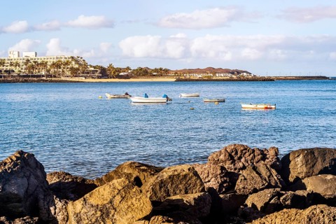 View of the resort town named Costa Teguise with boats on the foreground