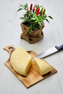 Fresh Adyghe cheese cut on slices on wooden cutting board