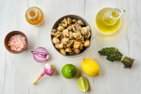Top view of mussels in bowl with spice and herbs