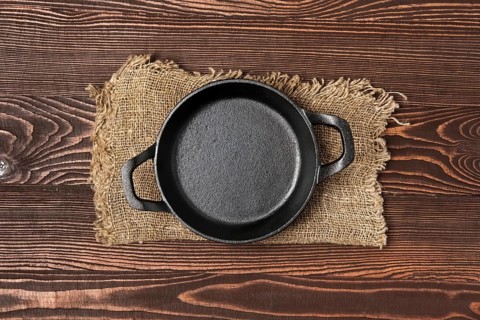 Empty mini cast-iron skillets on wooden table