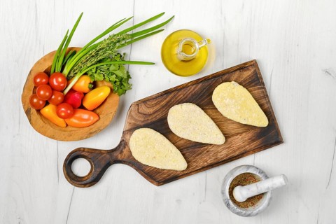 Top view of semifinished homemade zander cutlet on a wooden serving board