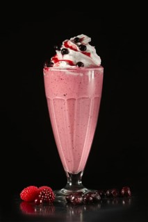 Glass of fruit cocktail on black background