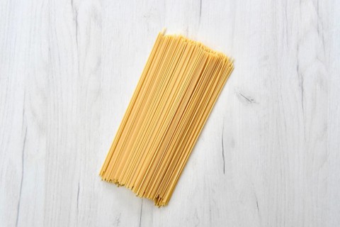 Overhead view of raw spaghetti on wooden table