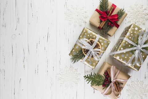 Collection of present boxes in christmas wrap between ornament snowflakes