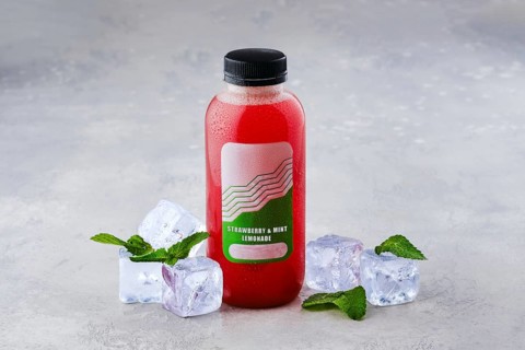 Small bottle with strawberry and mint ice lemonade on the table