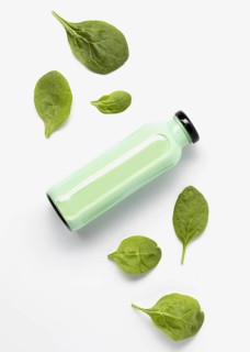 Flat lay juice bottle with spinach leaves