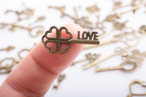 Hand and retro style metal keys on a white background