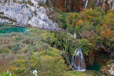 Hikers on wooden footbridge in Plitvice Lakes National Park