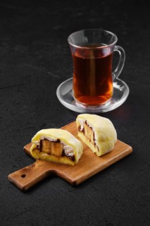 Sweet dessert mochi with banana and chocolate cut on half with fruit tea